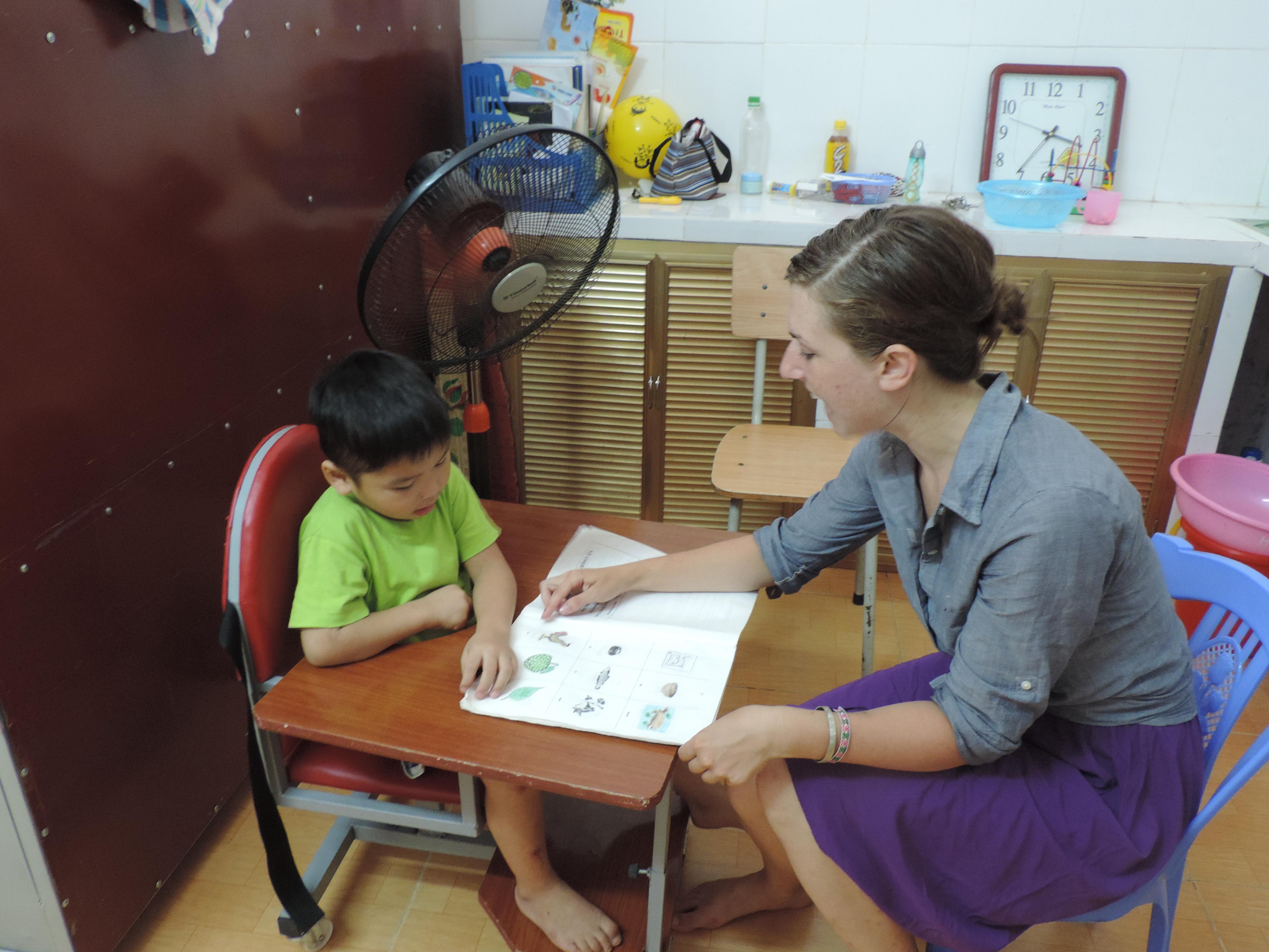 An intern from Projects Abroad reading to a child in a classroom whilst on her physiotherapy internship in Vietnam. An intern is pictured reading to a child during her physiotherapy internship in Vietnam with Projects Abroad.